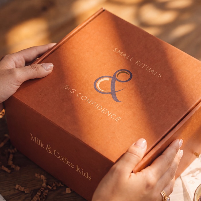 The Milk and Coffee Kids mailer closed, the ampersand mark and both taglines across the lid