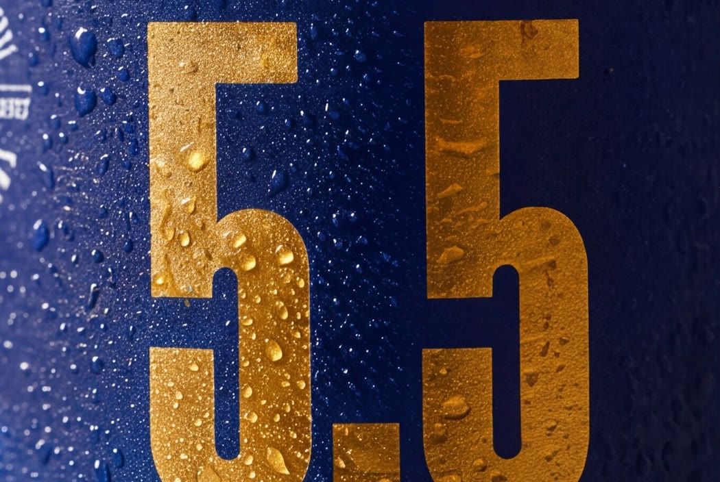 Macro of the raised gold five point five on the blue label, catching the light through the condensation